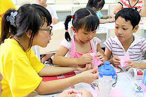 “新市民子女艺术课堂”教孩子们剪纸